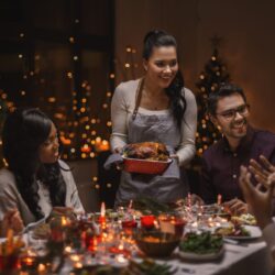 happy friends having christmas dinner at home